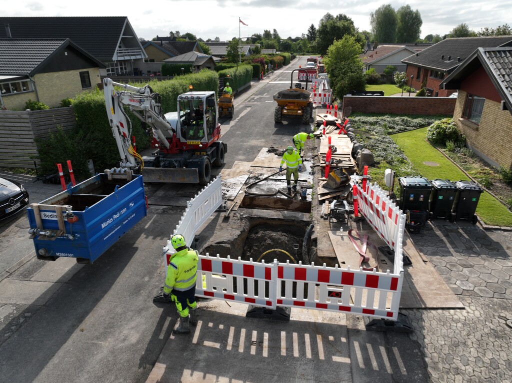 Arbejdere graver huller i jorden i byrum som led i installation af kabler til gadebelysning og infrastruktur