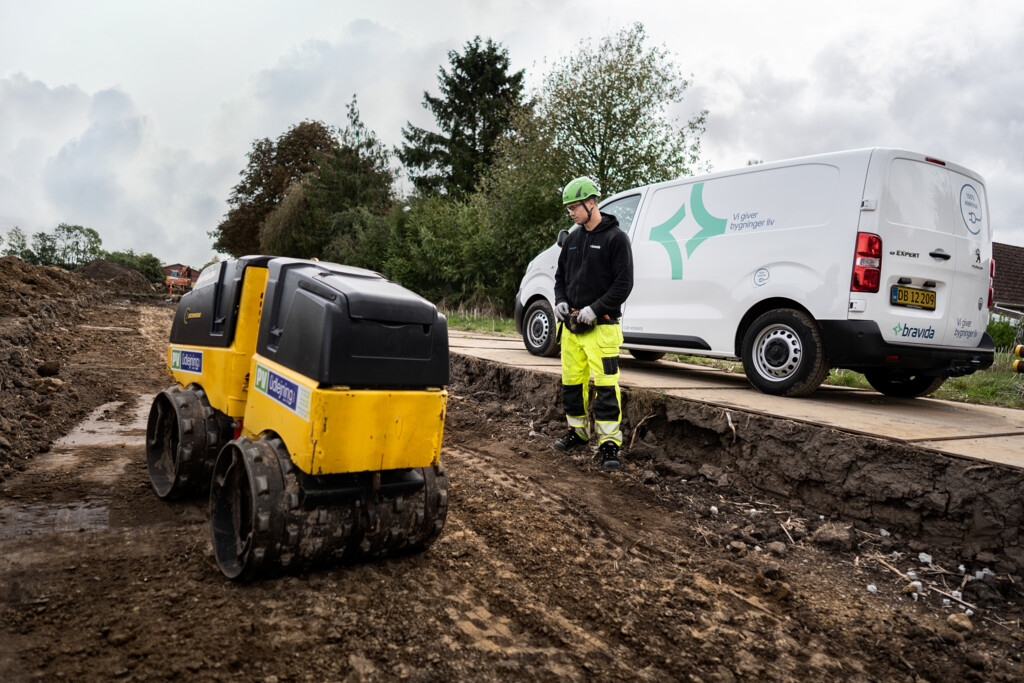 Mand udfører professionelt gravearbejde og kabelnedgravning til installation af kabler i forskellige spændingsniveauer