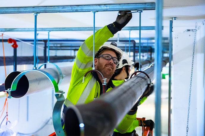  Ventilation installation is underway with a helmet, safety glasses and high-visibility clothing.