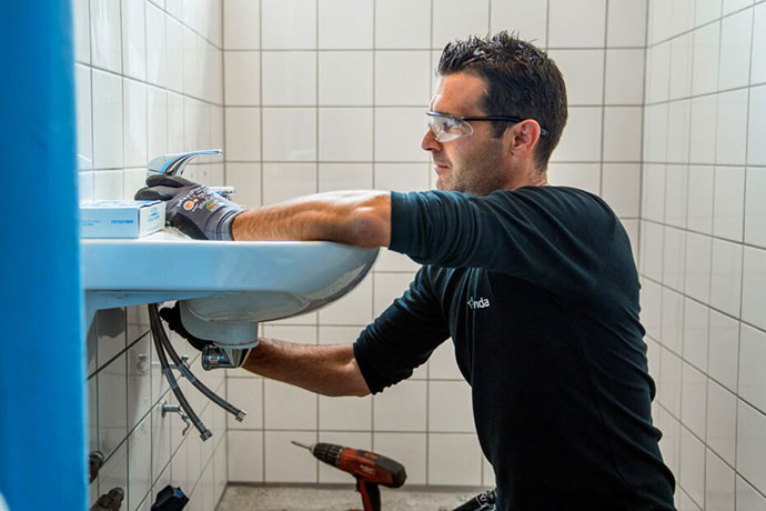 En vs-tekniker som installerar en badrumsblandare