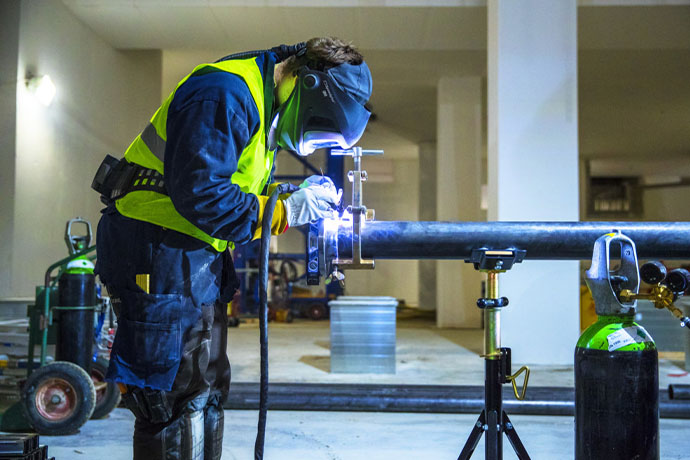 En vvs-tekniker som utför svetsarbete