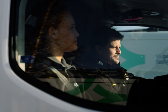 Bilden visar två servicetekniker i en servicebil 